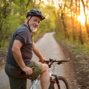 a man riding a bike down a dirt road